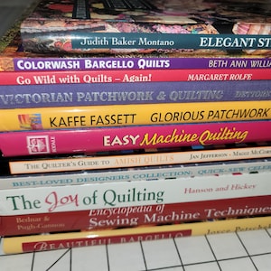 May include: A stack of quilting books with colourful covers. The titles include "Colorwash Bargello Quilts", "Go Wild with Quilts - Again!", "Victorian Patchwork & Quilting", "Kaffee Fassett Glorious Patchwork", "Easy Machine Quilting", "The Quilter's Guide to Amish Quilts", "Best-Loved Designers Collection: Quick-Sew Celebrations", "The Joy of Quilting", "Encyclopedia of Sewing Machine Techniques", and "Beautiful Bargello".