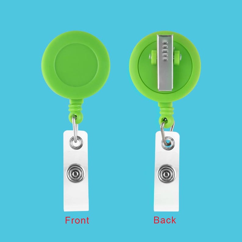 May include: A green retractable badge holder with a white card attached. The front of the holder is plain, while the back has a metal clip.