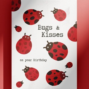 Op de afbeelding: Een witte kaart met rode lieveheersbeestjes en de tekst "Bugs & Kisses on your Birthday".
