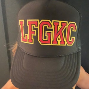 May include: Black mesh trucker hat with a red and yellow embroidered "LFGKC" logo.
