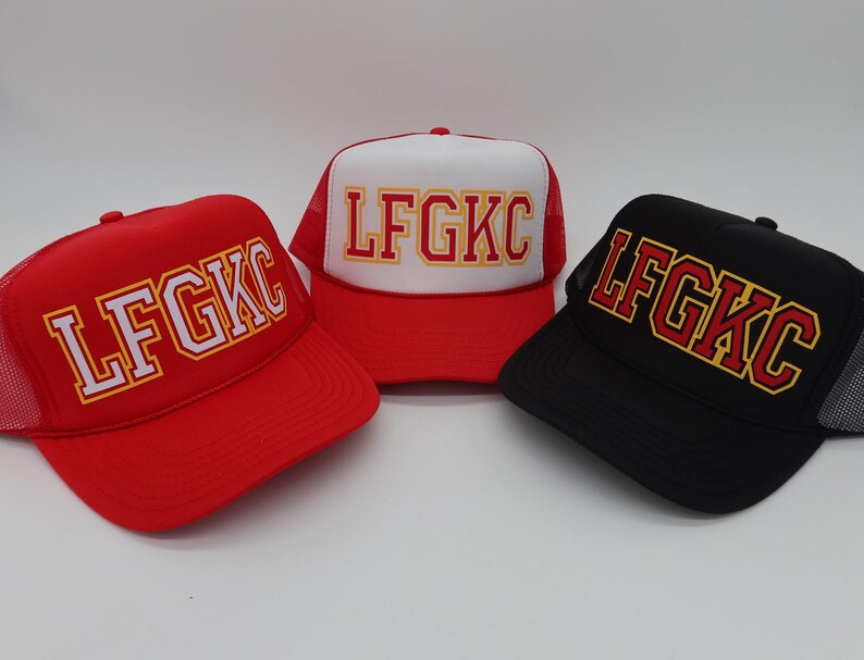 May include: Three trucker hats with a red, white and black mesh back. The hats have a white, red and black brim. The front of each hat has the text "LFGKC" in white, red and yellow letters.