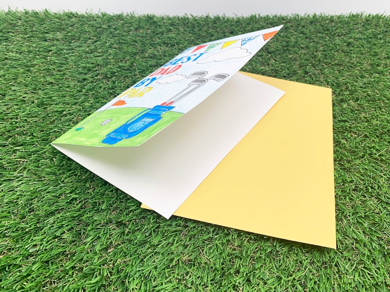 May include: A folded card with a yellow envelope. The card has a drawing of a golf bag with clubs and the text "Best Dad By Par". The card has a blue, green, yellow, red, and white colour scheme.