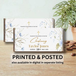 May include: Two rectangular favours with a floral design and the text "Christening of Taylor Jones, Sunday 18th May 2030." The favours have a gold cross and the words "Thank you for joining us for the". The bottom of the image reads "Printed & Posted".