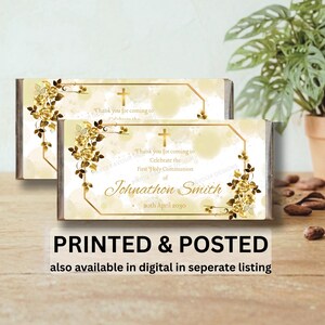 May include: Two rectangular chocolate bar wrappers featuring a gold hexagonal frame, gold roses, and a gold cross. The text reads: Thank you for coming to Celebrate the First Holy Communion of Johnathon Smith 20th April 2030.