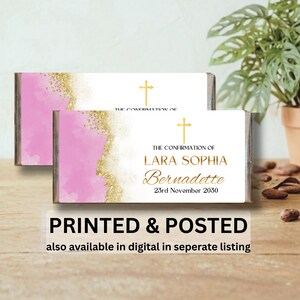 May include: Two rectangular chocolate bar wrappers featuring a white background with a pink watercolour wash and gold glitter accents. Each wrapper displays a gold cross and the text: THE CONFIRMATION OF LARA SOPHIA Bernadette 23rd November 2030.