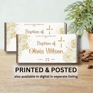 May include: Two rectangular baptism favours with a white background, gold text, and floral accents. The text reads "Baptism of Olivia Wilson" and "Thank you for celebrating the". The date "March 25 2030" is also visible.