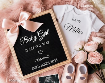 May include: A baby announcement featuring a black letter board with the text "Baby Girl Is On The Way Coming December 2025", a white onesie, pink baby shoes, and a sonogram image. A pink bow and roses complete the arrangement.