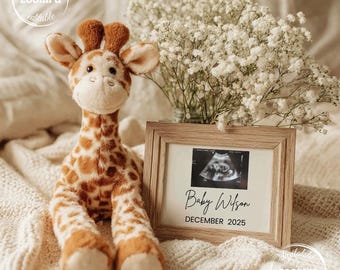 May include: A plush giraffe toy with brown spots and a framed sonogram image. The frame displays the text "Baby Wilson DECEMBER 2025" next to a bouquet of white flowers.