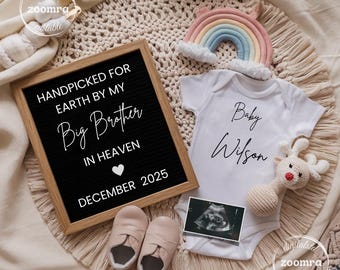 May include: A baby announcement scene featuring a white onesie with "Baby Wilson" written on it, a framed letter board with text, baby shoes, a rainbow, a stuffed reindeer, and an ultrasound image. The letter board reads "HANDPICKED FOR EARTH BY MY Big Brother IN HEAVEN DECEMBER 2025."
