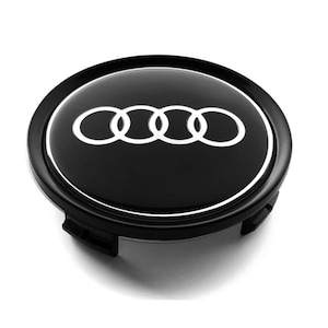 May include: Black car wheel center cap with a silver Audi logo. The logo is four interlocking rings.