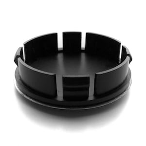 以下が含まれることがあります： 銀色の縁取りのある黒いプラスチック製のホイールセンターキャップ