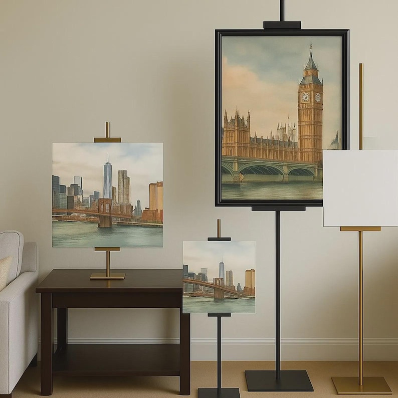 May include: Various sizes of black and gold easels displaying cityscape paintings. One painting depicts the Brooklyn Bridge and New York City skyline. Another shows the Big Ben clock tower and the Houses of Parliament.