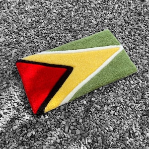 May include: A green, yellow, black, and red rug with a geometric design. The rug is made of a soft, plush material and is perfect for adding a pop of color to any room.