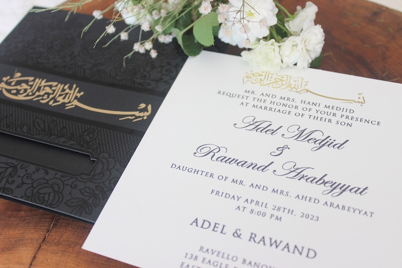 K&ouml;nnte beinhalten: Eine wei&szlig;e Hochzeitseinladung mit schwarzer und goldener Kalligraphie. Die Einladung verk&uuml;ndet die Hochzeit von Adel Medjid und Rawand Arabeyyat am Freitag, den 28. April 2023 um 20:00 Uhr.