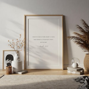 Puede incluir: Una impresión enmarcada con un marco de madera clara muestra el texto "CREATE IN ME A PURE HEART, O GOD, AND RENEW A STEADFAST SPIRIT WITHIN ME. Salmo 51:10." La impresión se exhibe en una habitación con objetos decorativos.