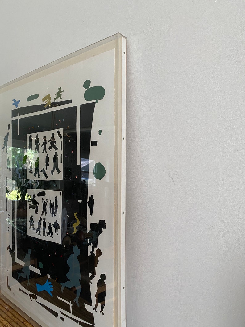 May include: A framed black and white print with a geometric design featuring silhouettes of people and trees. The print is set against a white background and has a white mat.