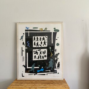 May include: A black and white print of a busy city scene with people walking in a maze-like pattern. The print is framed in a white frame and has a white mat.