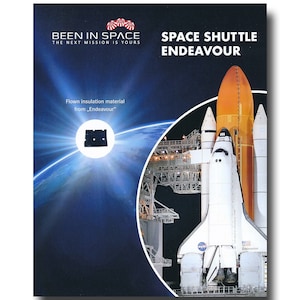 May include: A white and orange space shuttle with the text "Space Shuttle Endeavour" on the side. The shuttle is on a launchpad with a blue and green Earth in the background. The text "Been in Space" is at the top of the image with the text "The next mission is yours" below it. The text "Flown insulation material from "Endeavour"" is in the lower left corner of the image.