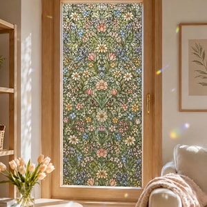 May include: A window film featuring a dense, repeating botanical pattern of green leaves, vines, and various small flowers in shades of pink, yellow, white, and light blue. The design covers the entire glass pane of a wooden door, creating a stained glass effect.