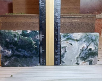 May include: Two green, blue, and white agate bookends with a wood base. The bookends are approximately 2.5 inches tall.