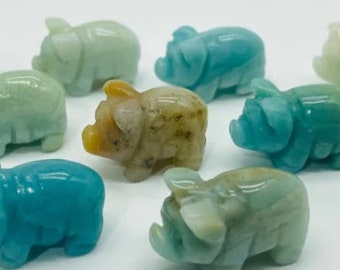 May include: A collection of nine small, carved pig figurines made of green, blue, and brown aventurine. The figurines are all different sizes and shapes, but they all have the same basic pig shape.