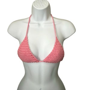 May include: A pink crocheted bikini top with a triangle shape.