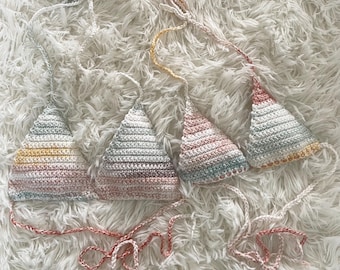 May include: Three crocheted triangle bikini tops in different color combinations. The tops are made with a multi-colored yarn with stripes of pink, yellow, blue, and white.