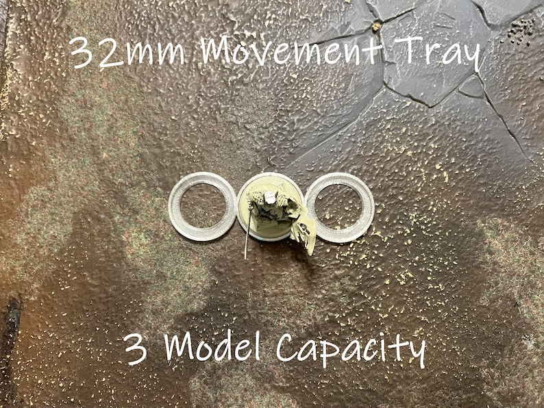 May include: A 32mm movement tray with three circular cutouts for miniature figures. The tray is made of a brown material with a textured surface. The text "32mm Movement Tray" and "3 Model Capacity" is printed on the tray.
