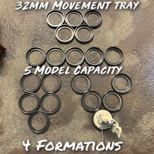 May include: A 32mm movement tray for miniature wargaming. The tray has a 5 model capacity and 4 formations. The tray is made of black plastic and is shown on a brown surface.
