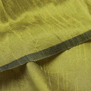 Könnte beinhalten: Nahaufnahme eines grünen Stoffes mit einem dezenten Streifenmuster. Der Stoff fühlt sich weich und strukturiert an und hat einen leicht glänzenden Schimmer.