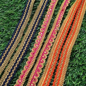 May include: Assortment of gold, black, orange, and pink trim with a wavy, scalloped design. The trim has a sparkly, glittery finish.