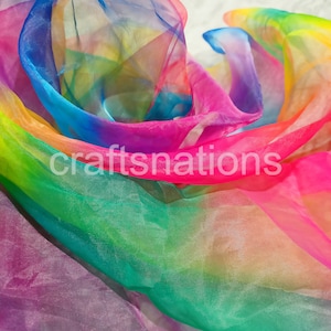 May include: A flowing, sheer fabric in a vibrant rainbow of colors, including pink, blue, green, and yellow. The fabric is layered and appears to be lightweight, with the text "craftsnations" printed across it.