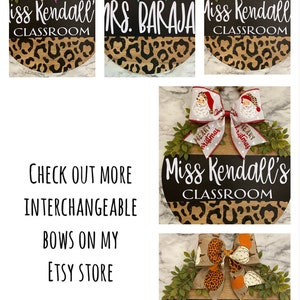 May include: Wooden classroom signs with interchangeable bows. The signs have a black top with white text and a leopard print bottom. The bows feature various designs, including hearts, shamrocks, and Santa Claus.