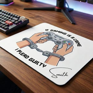 May include: White rectangular gaming mousepad with the text "IF GAMING IS A CRIME I PLEAD GUILTY". The design features hands in handcuffs holding a video game controller. A name is written in cursive at the bottom.