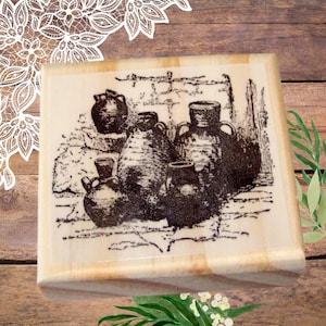 May include: A wooden box with a vintage illustration of five ceramic jugs in black and white. The jugs are arranged in a cluster, with some partially overlapping.