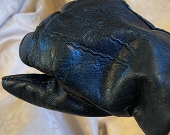 May include: A pair of black leather gloves with a stitched seam detail.