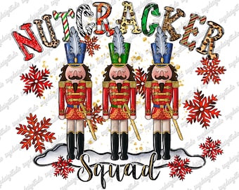 May include: A festive graphic featuring three nutcracker soldiers in red uniforms with gold accents, black boots, and feathered hats. The word "NUTCRACKER" is above them, and "Squad" is below. Red snowflakes and gold glitter complete the design.