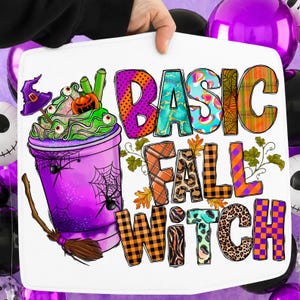 May include: A white rectangular sign featuring a purple cup filled with green whipped cream, a pumpkin, and a witch hat. The text reads BASIC FALL WITCH in colorful, patterned letters. A broomstick and spider web graphics are also included.