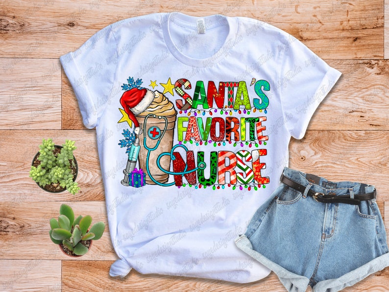 Puede incluir: Camiseta blanca con el texto "SANTA'S FAVORITE NURSE" en letras coloridas. El dise&ntilde;o incluye un gorro de Pap&aacute; Noel, una taza de caf&eacute;, un estetoscopio, una jeringa y una caja de regalo. La camiseta se combina con pantalones cortos vaqueros y un cintur&oacute;n.