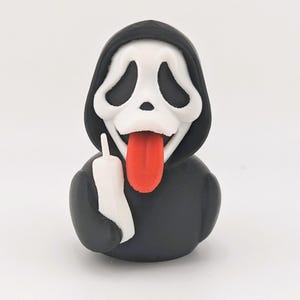 May include: A 3D-printed figurine of the Ghostface character from the Scream horror film series. The figure is black with a white mask, a red tongue sticking out, and a white hand giving the middle finger.
