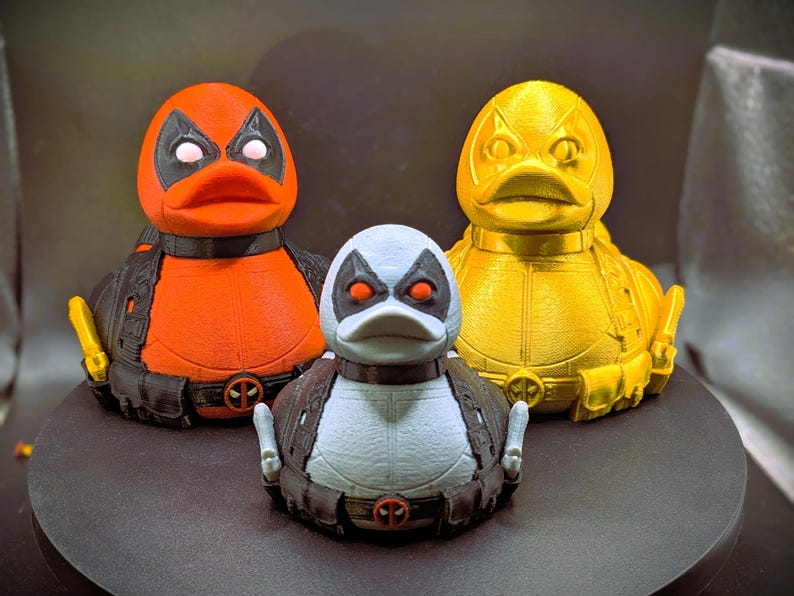 以下が含まれることがあります： 3つのゴム製のオモチャの鴨、それぞれ色が異なり、デザインも異なります。最初の鴨は赤と黒、2番目は白と黒、3番目は黄色と黒です。