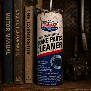 May include: A cylindrical tumbler featuring a distressed, weathered design mimicking a Lucas Oil Products Non-Chlorinated Brake Parts Cleaner can. The white, red, and blue label includes the Lucas logo, text, and a brake disc graphic with a metal straw.