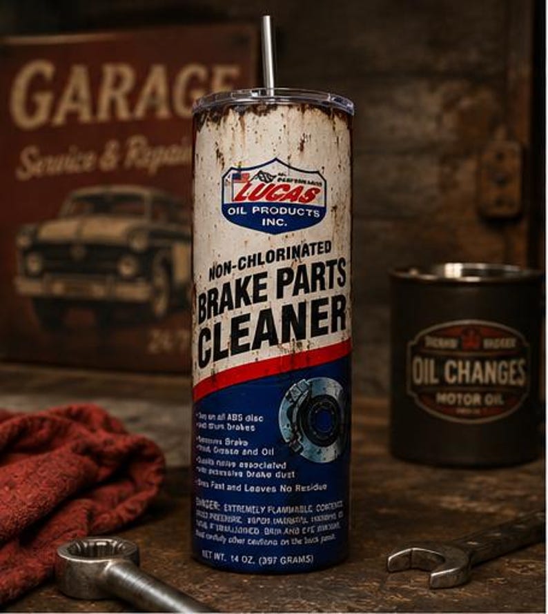 May include: A cylindrical tumbler featuring a vintage-style design that mimics a can of Lucas Oil Products Non-Chlorinated Brake Parts Cleaner. The exterior has a distressed, rusted appearance with blue, red, and white graphics and text.