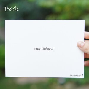 May include: A white card with the text "Happy Thanksgiving!" written in black ink. The card is blank on the front and has the name "SMADAR GROSSMAN" printed in the bottom right corner.