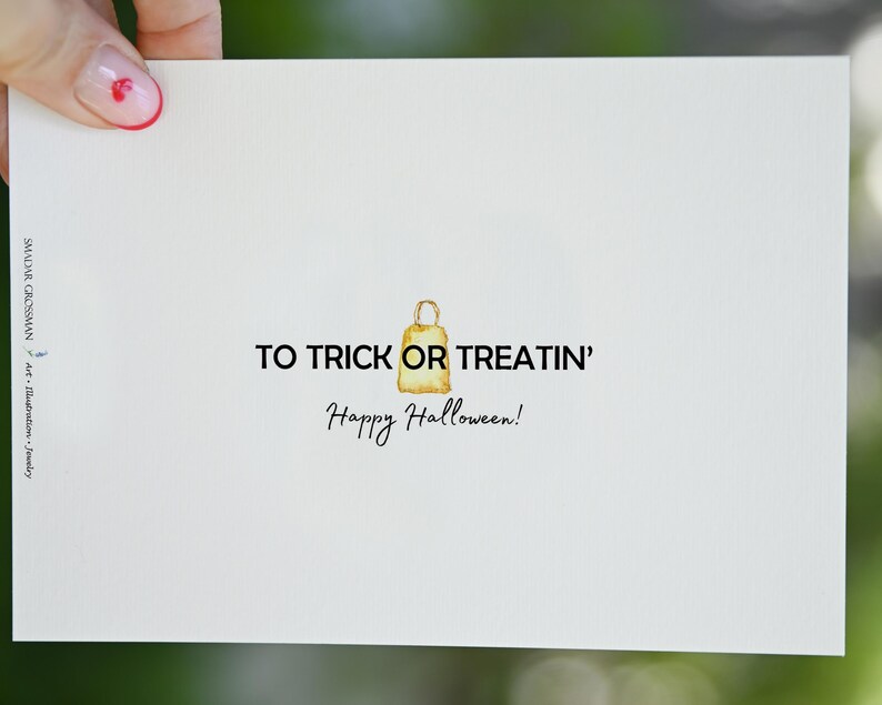 May include: A white card with the text "To Trick or Treatin' Happy Halloween!" and a watercolor illustration of a brown paper bag.