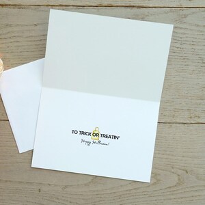 May include: A white card with the text "To trick or treatin' Happy Halloween!" and a small yellow illustration of a trick-or-treat bag.