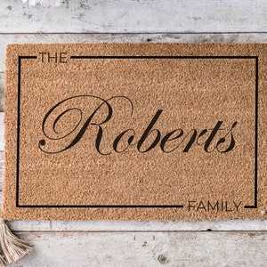 May include: A brown coir doormat with a black border and the text "THE Roberts FAMILY" in a cursive font.