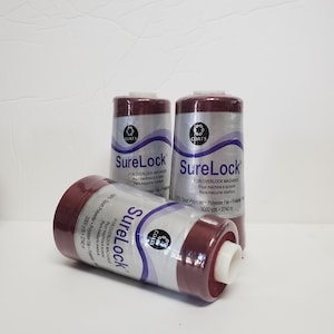 May include: Three spools of maroon thread labeled "SureLock" for overlock machines. The thread is 100% spun polyester and is 3000 yards (2740 meters) long.