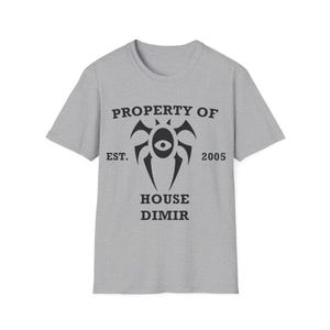 May include: A heather gray t-shirt with a crew neck. The front of the shirt features a black graphic design with the text "PROPERTY OF", "EST. 2005", and "HOUSE DIMIR". The graphic is a stylized eye within a symbol.