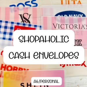 May include: A selection of clear plastic cash envelopes featuring brand logos like Victoria's Secret and Old Navy. The text "SHOPAHOLIC CASH ENVELOPES" is displayed, with "A6/PERSONAL" at the bottom, ideal for budgeting.